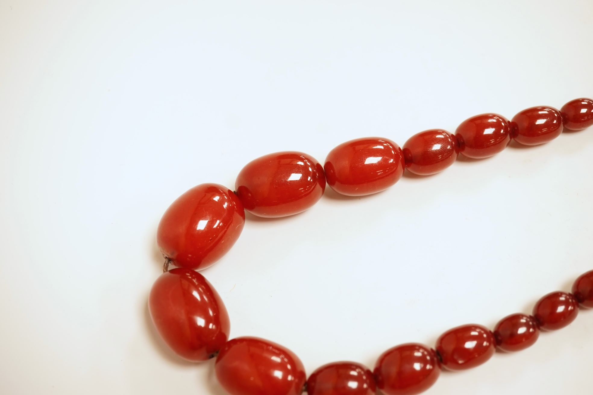 A single strand graduated simulated cherry amber bead necklace, 76cm, gross weight 75 grams.